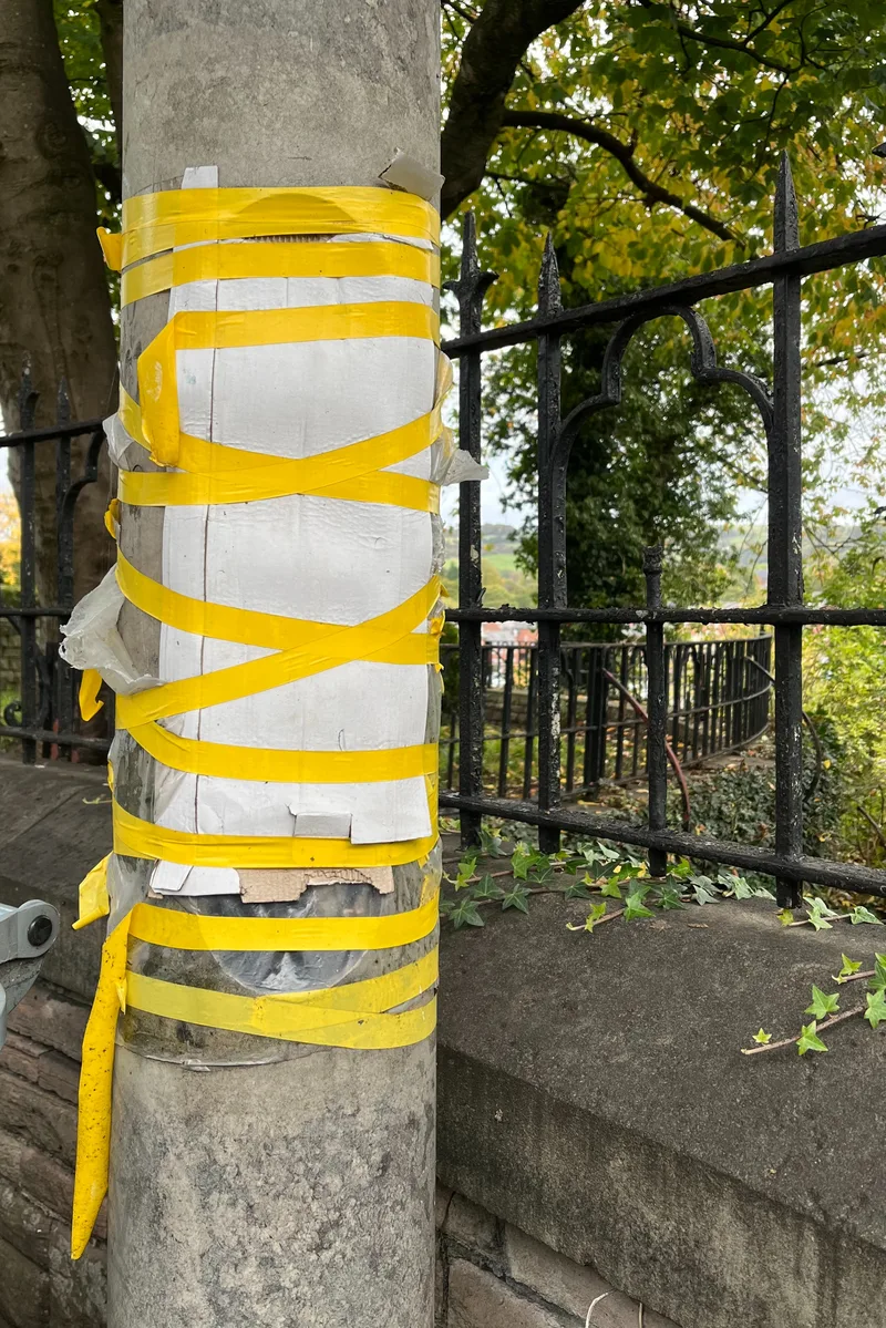 Yellow tape around a blank notice on a lamppost