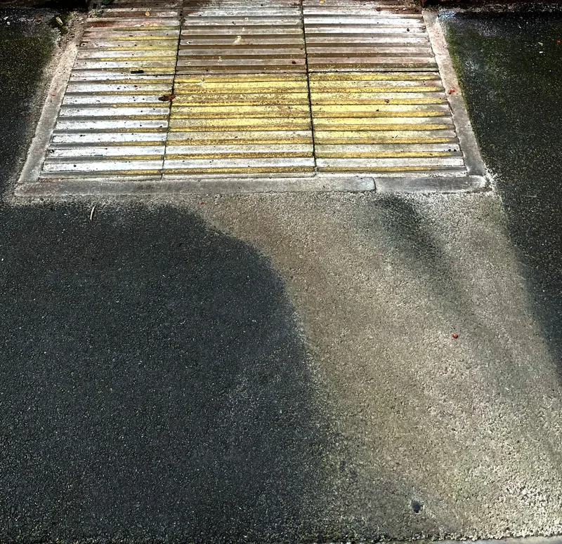 Colour flooding from a grid across  black asphalt.